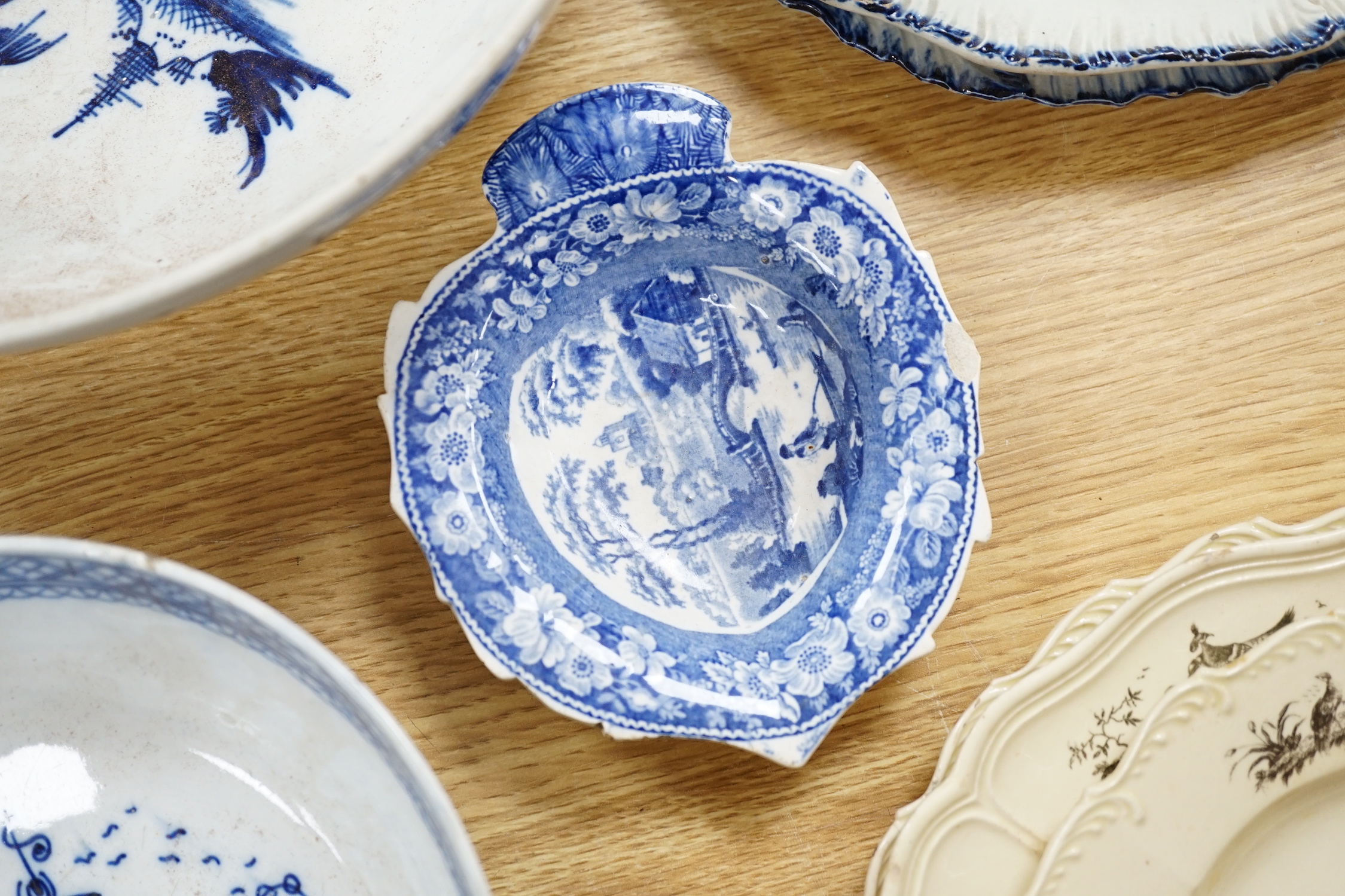 A collection of late 18th/early 19th century pearlware and creamware including three black transfer printed creamware plates, c.1780, blue and white bowls, plates, dishes and jug, the largest 27cm in diameter